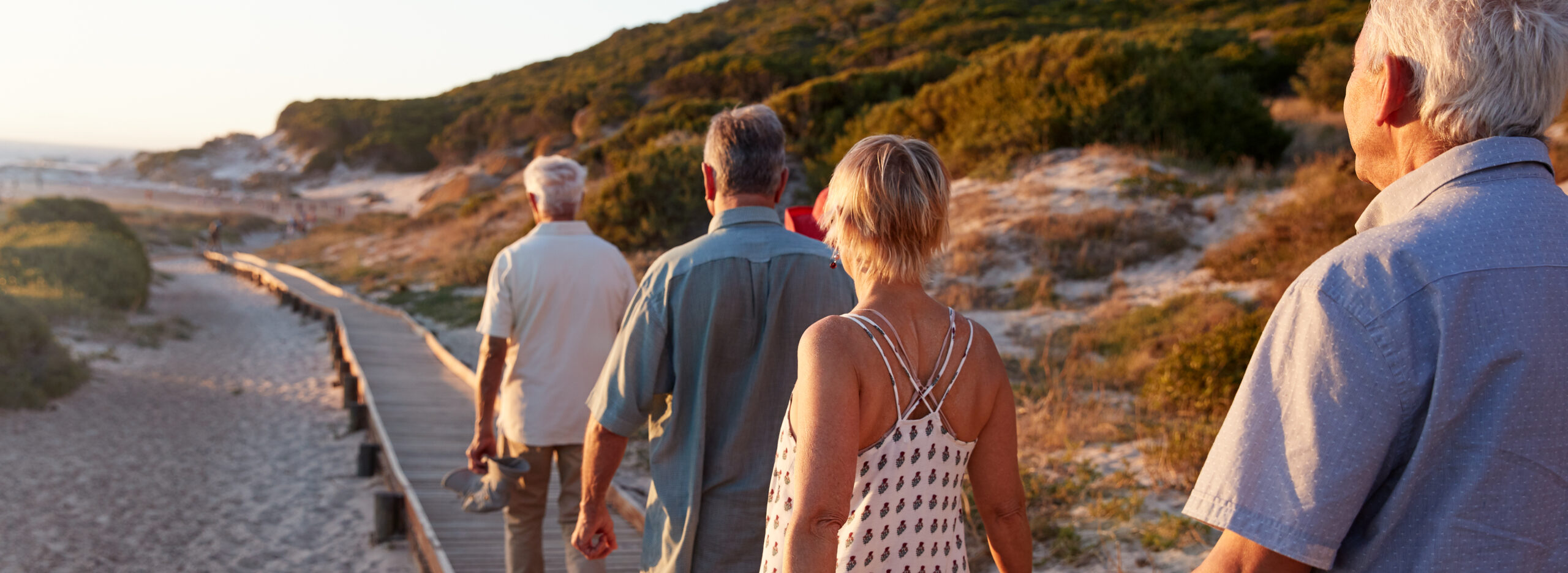 Group Of Senior Friends Walking Along Boardwalk At Beach On Summer Group Vacation Group Of Senior Friends Walking