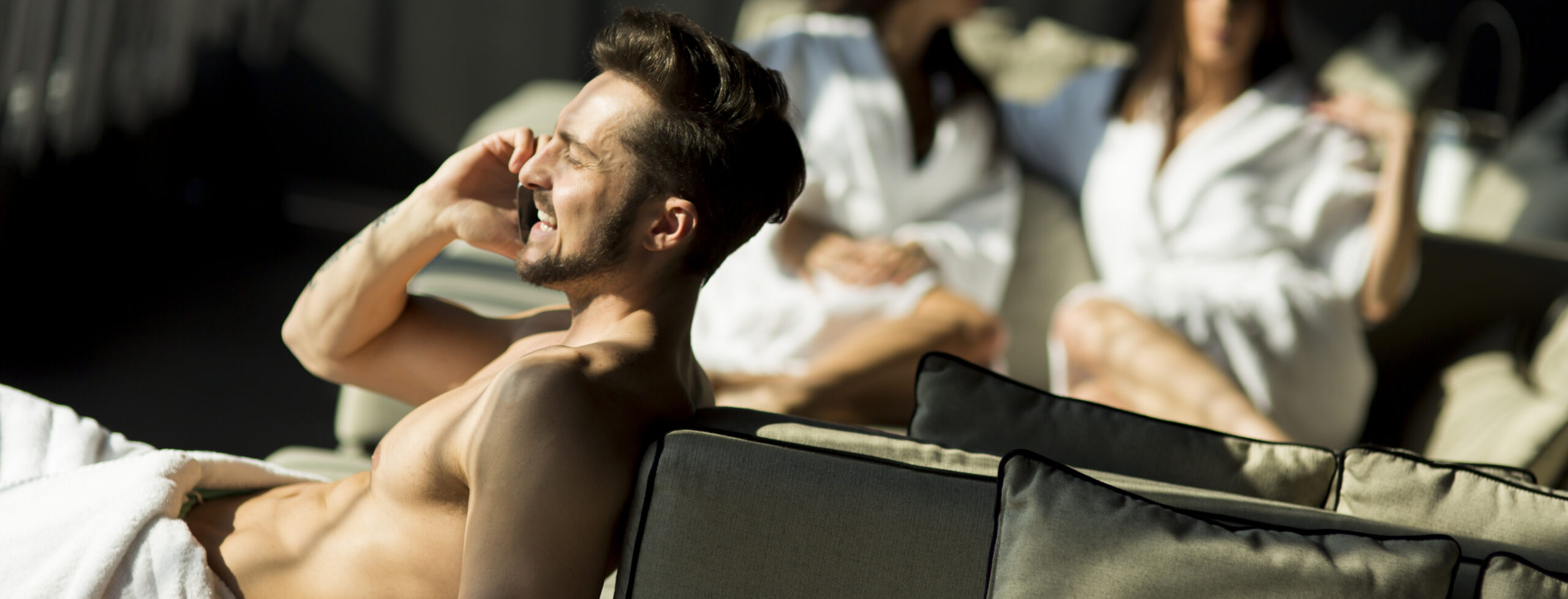 Man with a towel on the phone man relaxing with friends in indoor lounge 2026 09 23 17 52 10 utc cr scaled